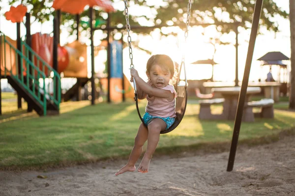 Asiatique fille jouer sur une balançoire et avoir du plaisir dans parc — Photo