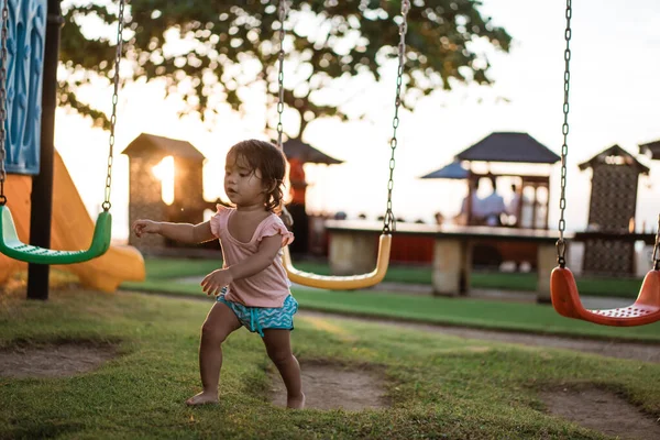 Азиатка играет на качелях и веселится в парке — стоковое фото