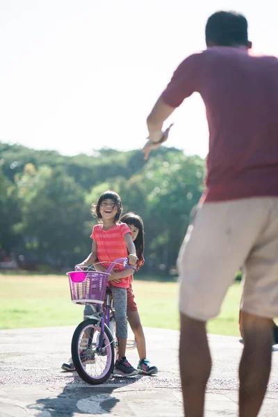 Apa tanítja a lányát biciklizni a parkban. — Stock Fotó