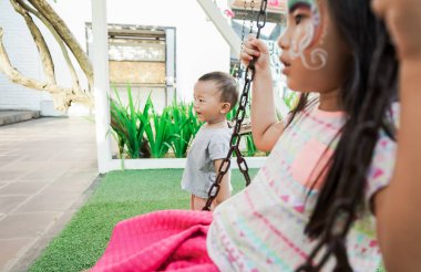 Asyalı çocuk dışarıda oyun oynuyor.