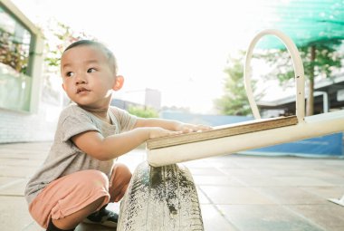 Asyalı çocuk dışarıda oyun oynuyor.