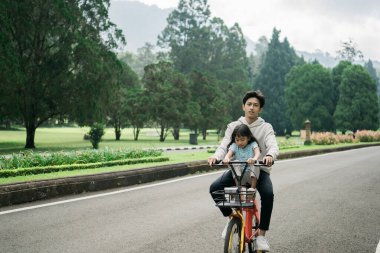 Abi, kız kardeşini bisikletle parka götür.