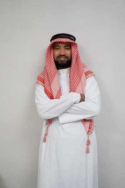 Arabski młody człowiek w turbanie, uśmiechnięty ze skrzyżowanymi rękami — Zdjęcie stockowe