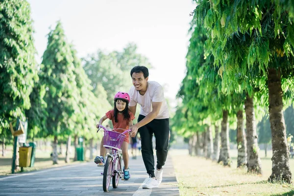 Padre Insegnamento figlia di andare in bicicletta nel parco — Foto Stock