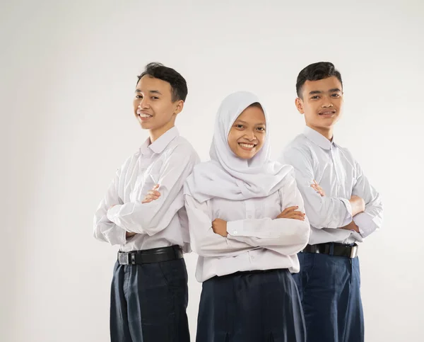 Tiga remaja berseragam SMP berdiri tersenyum dengan bergandengan tangan — Stok Foto