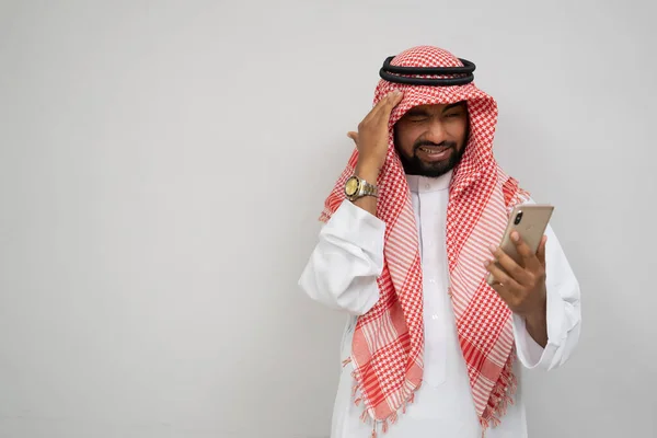 Arabski turban jest zawroty głowy podczas korzystania z telefonu komórkowego z rękami trzymającymi głowę — Zdjęcie stockowe