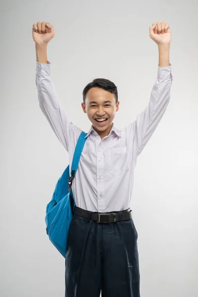 A boy raised hands in junior high school uniform smiling with school bag — Stock Photo, Image
