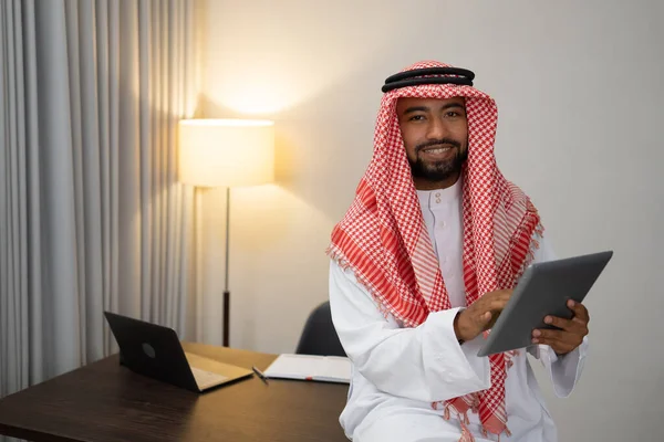 En arabisk affärsman som använder en bärbar dator fungerar stående vid ett skrivbord — Stockfoto