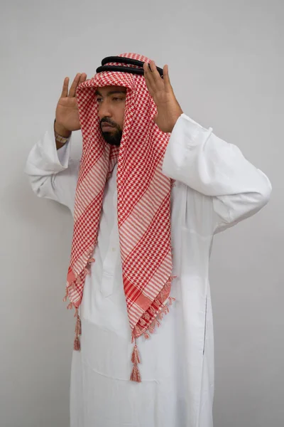 Araber i turban ber under itidal med två händer bredvid huvudet — Stockfoto