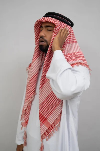 Ein arabischer Muezzin im Turban verrichtet den Gebetsruf mit einer Hand am Ohr — Stockfoto