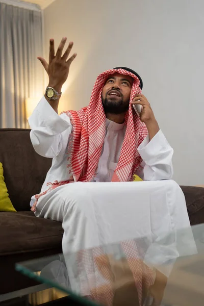 Un homme d'affaires arabe portant un turban à l'aide d'un téléphone portable passe un appel avec des gestes de main — Photo