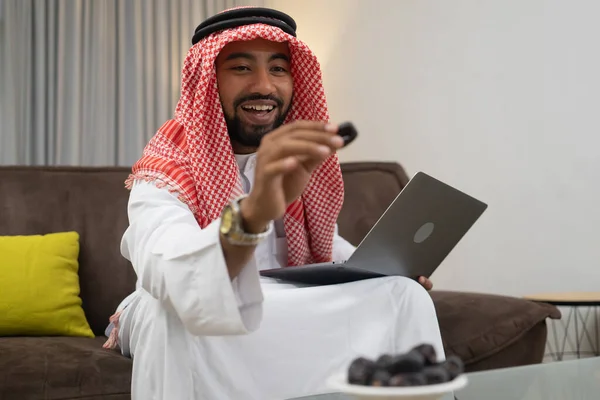 Un homme d'affaires arabe portant un turban souriant tout en tenant un rendez-vous tout en travaillant avec un ordinateur portable — Photo