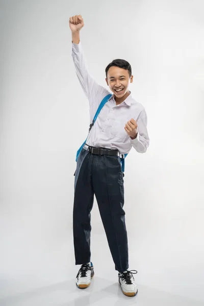 Usmívající se chlapec nosí školní uniformu, nosí batoh a zvedá ruku — Stock fotografie