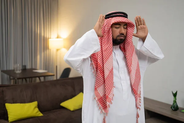 En arab i en turban ber under takbir rörelsen med två händer — Stockfoto