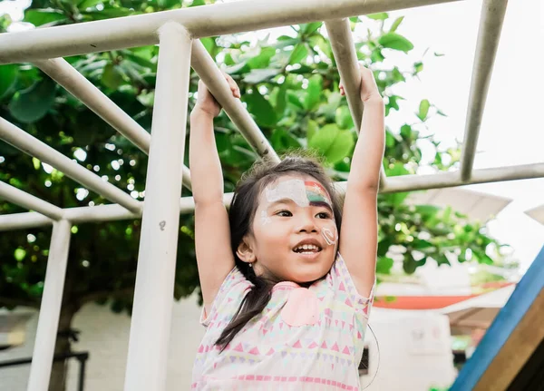 Gesundes Mädchen hängt auf dem Spielplatz an einer Stange — Stockfoto