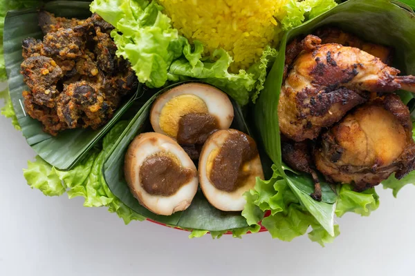 Nasi tumpeng. indonéská kuchyně žlutá rýže na banánovém listu — Stock fotografie