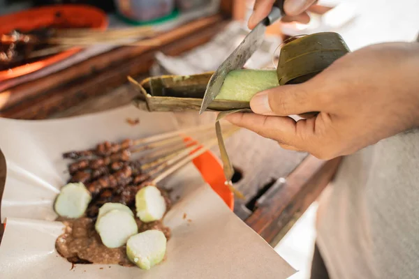 Sate ayam bereiding geserveerd met rijstkoek of lontong met pinda saus op voedselpapier — Stockfoto
