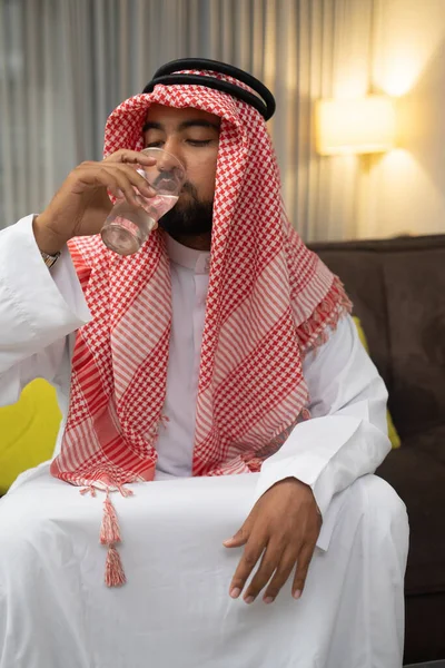 Arab w turbanie pijący wodę ze szklanką, gdy łamie swój post — Zdjęcie stockowe