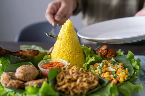 Nasi tumpeng. cozinha indonésia arroz amarelo em folha de banana — Fotografia de Stock