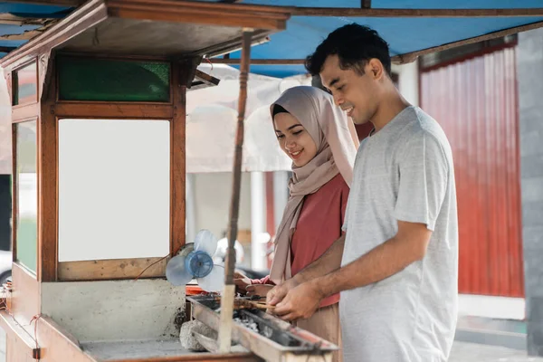 Dua penjual menyiapkan makanan di kios makanan mereka menjual sate ayam tradisional — Stok Foto