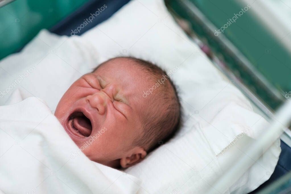 new born infant asleep in the blanket in delivery room