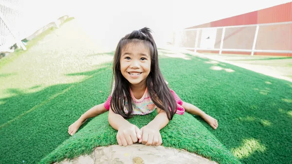 Kleines gesundes Mädchen hängt auf dem Spielplatz an einer Stange — Stockfoto