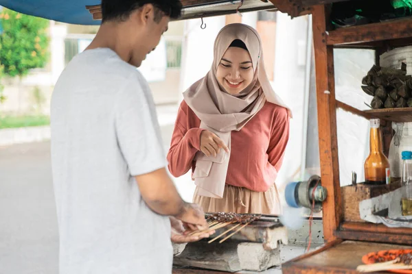 Mulher ordenando satay frango no vendedor de comida de rua — Fotografia de Stock