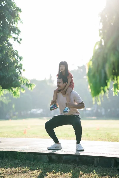 Asijský otec a malá dcera dělají cvičení ve venkovním prostředí. Zdravý životní styl rodiny s dítětem — Stock fotografie