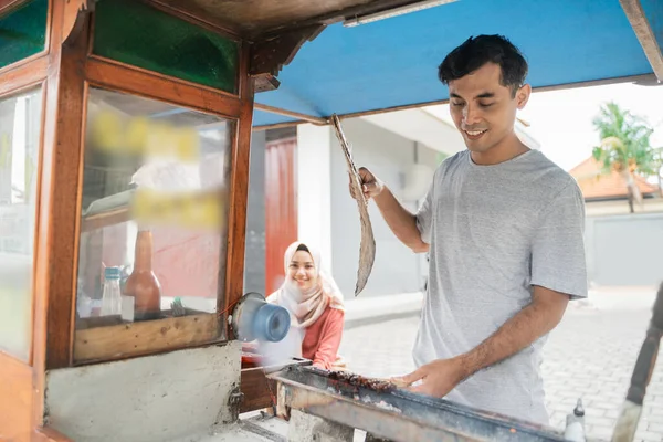 Человек уличный продуктовый продавец курицы сатэй с продовольственной тележкой, продающей сатэ аям. — стоковое фото