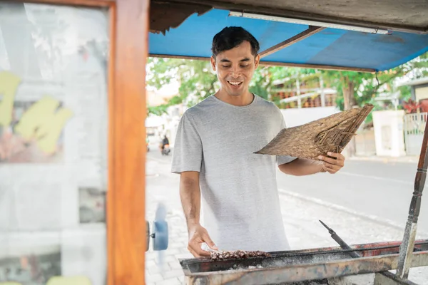 Homem rua vendedor de comida de frango satay com carrinho de comida vendendo sate ayam. — Fotografia de Stock