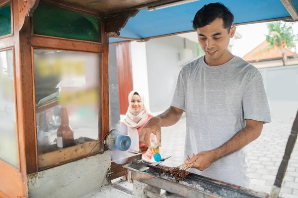 Homem rua vendedor de comida de frango satay com carrinho de comida vendendo sate ayam. — Fotografia de Stock