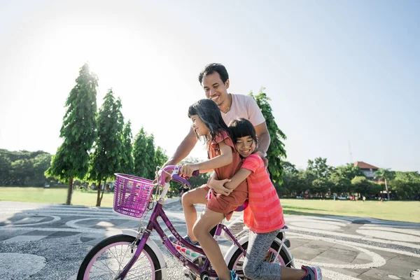 Padre Enseñando a su hija a Montar en Bicicleta en el parque —  Fotos de Stock