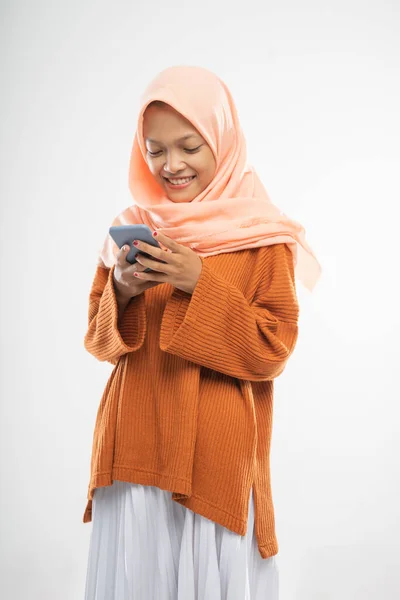 Uma menina usando um encapuzado stands segurando um celular — Fotografia de Stock
