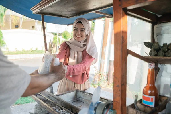 Müslüman kadın tavuk satayından yemek siparişini alıyor. — Stok fotoğraf
