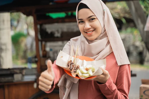 Cliente feliz desfrutando satay frango e mostrando polegar para cima — Fotografia de Stock