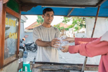 Müslüman kadın küçük yemek arabasından tavuk siparişi veriyor..
