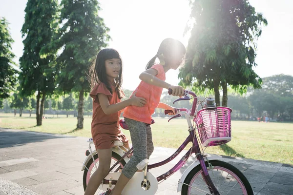 Dos niños disfrutan de paseo en bicicleta en el parque juntos —  Fotos de Stock