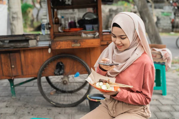 Pollo satay comprador tomar foto de su comida usando el teléfono inteligente — Foto de Stock