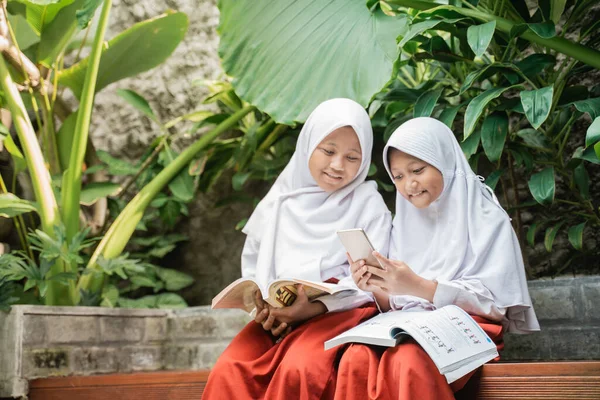 Двое детей в школьной форме используют смартфон во время обучения — стоковое фото