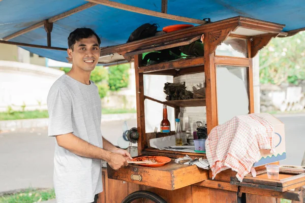 Mann Streetfood-Verkäufer von Chicken Satay mit Essenswagen Verkauf von Sate Ayam. — Stockfoto