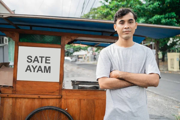 Hombre calle comida vendedor de pollo satay con comida carro venta sate ayam. — Foto de Stock