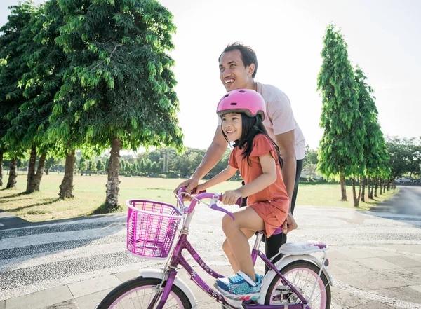 父亲在公园教女儿骑自行车 — 图库照片