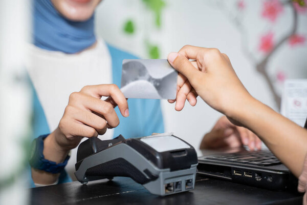 закрытие рук, держащих кредитную карту при безналичной оплате с помощью EDC-автоматов