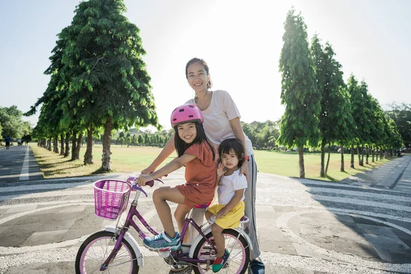 母は公園で自転車に乗るために娘を教える — ストック写真