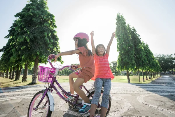 Duas crianças desfrutar de passeio de bicicleta no parque juntos — Fotografia de Stock