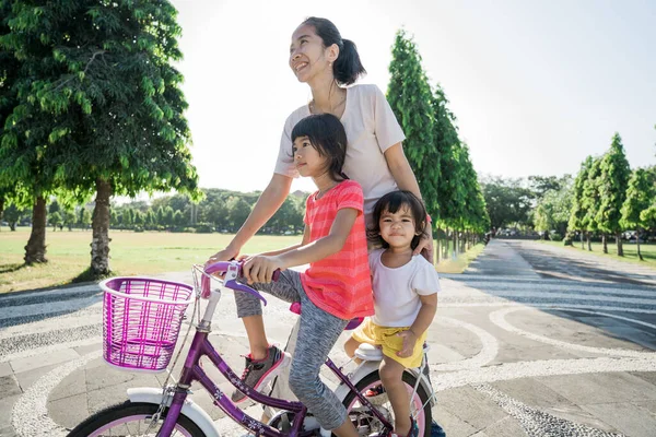 Mãe Ensinando filha a andar de bicicleta no parque — Fotografia de Stock