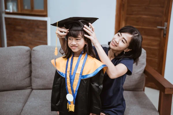 Ázsiai anya és gyerek készül a kedvesebb diplomás nap otthon — Stock Fotó