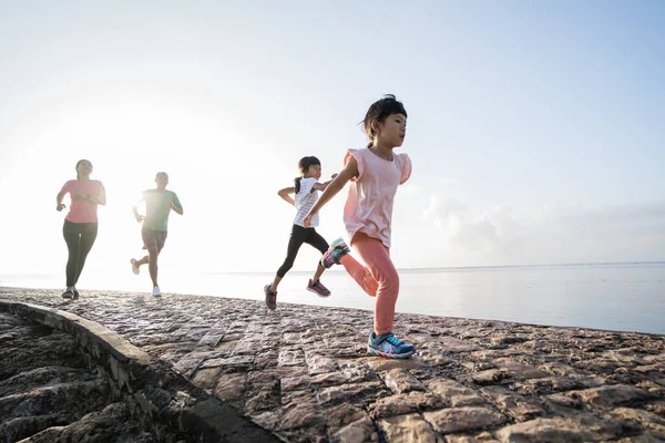 Padres asiáticos y niños corriendo deporte al aire libre. —  Fotos de Stock