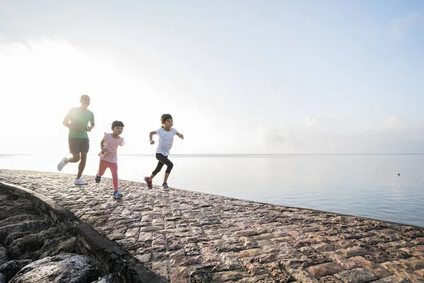 Pai e filha fazem exercícios correndo ao ar livre correndo uns aos outros — Fotografia de Stock