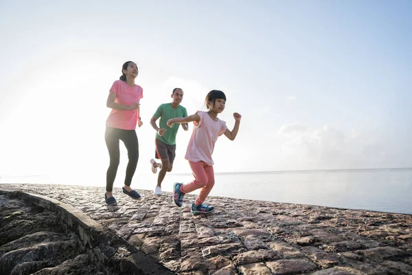 Asijské rodiče a děti běží sport venku. — Stock fotografie